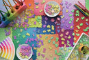 A vibrant layout of the Karen Puzzles on Puzzles 3000 jigsaw puzzle by Ravensburger, featuring colorful puzzle pieces scattered across a multicolored base. A bowl of spare pieces and a watercolor palette are visible, along with colored pencils and a succulent plant, showcasing a creative and engaging puzzle assembly process.