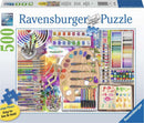 The Artist's Palette Large Piece Puzzle by Ravensburger featuring a colorful assortment of art supplies including paint tubes, brushes, a palette with paint spots, and a sketchbook filled with floral designs. The puzzle showcases vibrant colors and a creative theme, ideal for art lovers.