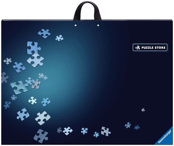 Ravensburger Puzzle Store Accessory featuring an elegant design with scattered jigsaw puzzle pieces against a deep blue background. The product has a convenient handle for easy transport and showcases the Ravensburger logo.