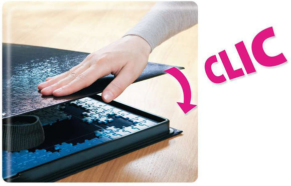 A person gently sliding a protective cover over a jigsaw puzzle stored in a box. The hand is positioned carefully to ensure the puzzle pieces are secured. The jigsaw puzzle is well-organized, with pieces visible inside a compartment. The scene conveys the ease of storage and transport for puzzle enthusiasts.