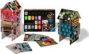 Eames House of Cards jigsaw puzzle by Ravensburger, featuring colorful designs and unique patterns on each card. The kit showcases a completed three-dimensional house made from cards and a collection of flat cards displaying artful designs, perfect for creative building and play.