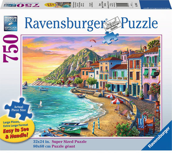 A colorful jigsaw puzzle box showcasing a vibrant sunset over a coastal village with colorful houses, beach chairs, and boats in a serene harbor setting by Ravensburger. The puzzle features 750 pieces and measures 32x24 inches when completed, emphasizing its Large and Easy-to-Handle design.