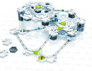 The GraviTrax Starter Set by Ravensburger, featuring a modular marble run design with various track pieces and connectors laid out on a hexagonal grid. The set includes vibrant green and blue elements, allowing for endless possibilities in building tracks that guide marbles through a network of paths. Ideal for encouraging STEM learning and creativity in kids.
