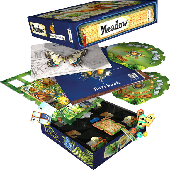 The game Meadow by Rebel displayed with its box and components. The box features beautiful illustrations of butterflies and plants. Inside, various cards, a rulebook, and game boards are arranged in a neat layout, showcasing vibrant graphics depicting nature elements. The game includes pieces that represent a colorful meadow environment.