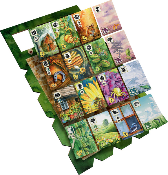A colorful board game titled 'Meadow' by Rebel. The game features a variety of beautifully illustrated cards showcasing different animals, plants, and landscapes, organized in a grid pattern. Each card displays unique score values and symbols, designed to encourage strategic gameplay and enhance interaction among players. The vibrant artwork features elements of nature, including a hut, flowers, and wildlife, highlighting the game's theme of exploring a meadow.