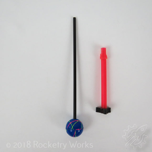The Reaction Rocket DIY kit by PlaySTEAM includes a colorful blue ball with paint designs, a black straw, and a bright pink launching tube, ideal for hands-on science experiments and fun educational activities.