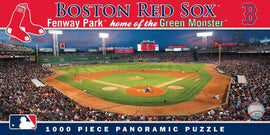 1000-piece jigsaw puzzle featuring a panoramic view of Fenway Park, home of the Boston Red Sox. The image showcases a vibrant game scene with fans in the stands, the iconic Green Monster in left field, and players on the field under a beautiful twilight sky.
