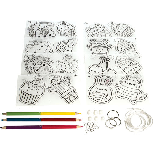 The Sweat Treats Shrinkies DIY kit by Tiger Tribe includes colorful pencils, shrink plastic sheets with fun designs of desserts and cute characters, paper fasteners, and elastic bands. Ideal for crafting and creative play.