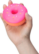 A person holding a squishy pink donut toy with colorful sprinkles. The donut has a rounded shape and is soft to the touch, perfect for stress relief and sensory play.