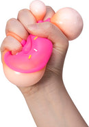 A hand squeezing a colorful NeeDoh Dohnuts stress ball from Schylling. The toy features a doughnut shape in pink with sprinkles, providing a satisfying sensory experience.