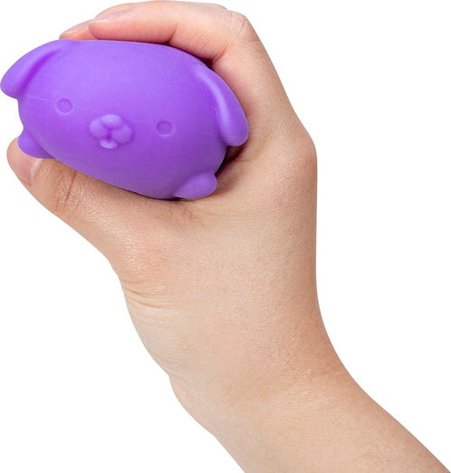 A hand squeezing a small, purple puppy-shaped stress ball. The stress ball has round ears, a snout, and a smooth texture, designed for fidgeting and relaxation.