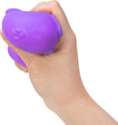 A hand holding a purple NeeDoh Funky Pup, a squishy fidget toy shaped like a cute puppy. The toy is designed for stress relief and fun squeezing.