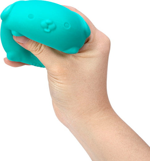 A hand holding a turquoise NeeDoh Funky Pup, a soft and squishy dog-shaped stress ball. The pup has a cute face, and its smooth texture makes it perfect for stress relief and sensory play.