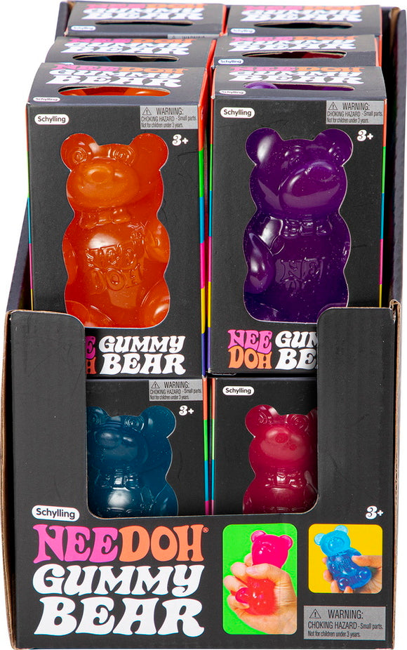 A colorful display of Needoh Gummy Bears in a box. The gummy bear figures are in various vibrant colors, including orange, purple, blue, and red. Each bear features a friendly face and is made from a stretchy, squishy material, suitable for stress relief or fidgeting, with a warning label indicating they are for ages 3 and up.