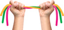 A pair of hands grasping colorful, flexible Noodies in green, pink, orange, and yellow. The hands are pulling the Noodies apart, showcasing their stretchability and vibrant colors.