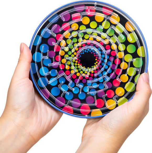 A person holding the colorful Tin BB Maze by Schylling, featuring a vibrant spiral design with large polka dots and a clear plastic maze structure on top. The maze is challenging and engaging, making it a fun toy for kids and adults alike.