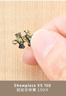 A close-up image of a hand holding a single jigsaw puzzle piece. The piece is intricately designed with a colorful pattern that includes shades of green and gold. This image represents the Puppies in a Gift Box XS 150 pc Puzzle by Pintoo, showcasing the quality and detail of its pieces.