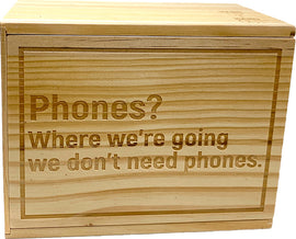 A wooden Device Detox Box by Solid Roots featuring an engraved message that reads, 'Phones? Where we're going we don't need phones.' The box is designed to help users disconnect from their devices and create a mindful environment.