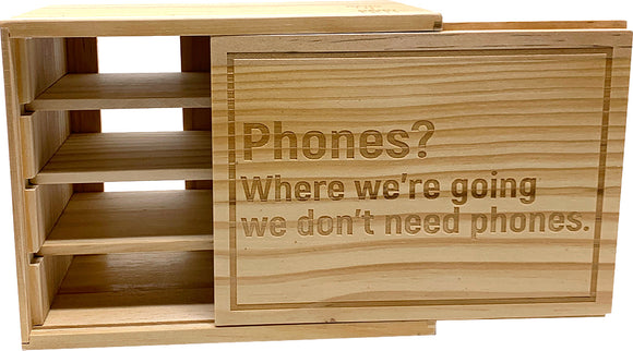 The Device Detox Box from Solid Roots is a beautifully crafted wooden storage box that promotes digital detox. It features a playful engraving that reads, 'Phones? Where we're going we don’t need phones.' The box includes multiple compartments for organizing devices or other personal items, encouraging a break from screens with its stylish yet functional design.