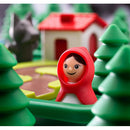 A colorful mechanical puzzle featuring a character of Little Red Riding Hood in a red hood, surrounded by green trees and a small house. The scene includes a wolf figure in the background, creating a whimsical fairy tale atmosphere.