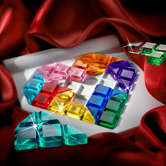 A colorful mechanical puzzle called IQ Love by Smart Toys & Games, featuring vibrant geometric pieces in various colors arranged to form a heart shape on a white board. The background is adorned with rich red fabric, enhancing the visual appeal and highlighting the dazzling, transparent pieces of the puzzle.