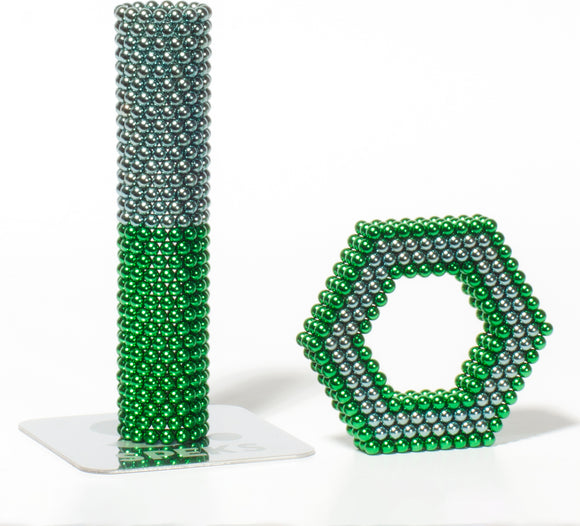 A colorful arrangement of magnetic balls forming a tall green and gray tower alongside a green and gray hexagonal structure. The product, Speks Stripes Third Rock by SPEKS, displays its vibrant colors and unique shapes, inviting creativity and imaginative play.