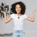 A joyful girl with curly hair wearing a white t-shirt and light blue jeans, showcasing a beautiful heart-shaped stone necklace. She is energetically raising her arms and smiling, surrounded by a soft, neutral background that highlights her expression and the necklace.