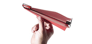 A hand holding the PowerUp 2.0 Electric Plane in a sleek red design. The airplane features a streamlined body for optimal aerodynamics and is equipped with a mini engine. Ideal for DIY enthusiasts, this model allows for easy assembly and flight testing.