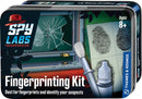 The Spy Labs Fingerprinting Kit by Thames & Kosmos features a colorful package showcasing a fingerprinting brush, a bottle for fingerprint powder, and prints displayed on paper. The background illustrates a scene with broken glass and a window, indicating a mystery to solve. Suitable for ages 8 and up, this kit encourages kids to explore forensic science through hands-on activities.