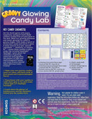 The Groovy Glowing Candy Lab STEM experiment kit packaging features a colorful design with the title prominently displayed. The contents include glowing fruit and pineapple candy mixtures, a plastic candy mold, a UV flashlight, and various tools for candy making. Instructions highlight the fun of making glowing gummy candies and exploring the science of luminescence.