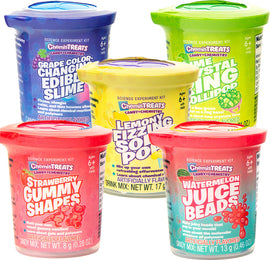 A colorful display of ChemisTreats! science experiment kits by Thames & Kosmos. The set features five containers: Grape Color-Changing Edible Slime, Lemony Fizzing Soda Pop, Crystal Ring Lollipop, Strawberry Gummy Shapes, and Watermelon Juice Beads. Each container is labeled with the flavor and educational focus of the kit. The products are designed for ages 6 and up, encouraging kids to explore candy-making chemistry through fun, hands-on experiments.