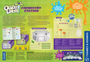 Ooze Labs Chemistry Station by Thames & Kosmos, featuring a large laboratory setup with colorful test tubes, beakers, and various experiment components. The kit includes experiment cards, a detailed manual, non-hazardous chemicals, and equipment for conducting fun and engaging science experiments. Perfect for budding chemists to explore slime, fizzing reactions, and color changes while learning the basics of chemistry safely.