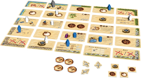 The board game Targi by Thames & Kosmos displayed with various game cards and player pieces scattered across a sandy terrain. The game features colorful meeples representing players and strategic elements for trade and resource management in a two-player setup. Each card depicts actions and resources related to game mechanics like raids and caravans, inviting strategic play.