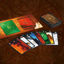 The game 'Lost Cities 2019 Edition' by Thames & Kosmos features vibrant cards laid out on a wooden table. The game elements include colorful location cards showcasing distinct landscapes in elaborate designs along with a game board that has a green and red layout. The cards are arranged to reflect the adventure and strategy involved in exploring lost cities, hinting at the game's engaging mechanics.
