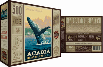 The Acadia Whale Watching jigsaw puzzle from True South Puzzles features a stunning illustration of a whale breaching near the rocky coastline of Acadia National Park. The puzzle, containing 500 pieces, measures 18 inches by 24 inches and is designed for ages 10 and up. The packaging displays vibrant artwork and includes historical details about the park.