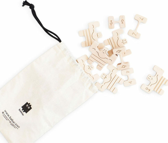 Circus Athletes game by Babai featuring playful wooden pieces that resemble circus characters. The pieces are scattered around a drawstring bag, showcasing their unique shapes and numbers. Ideal for imaginative play and creativity.
