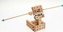 The Catapults Explorer DIY kit by Matador, featuring 56 wooden pieces designed for building a catapult. The assembly includes various colored pegs, showing intricate construction with precision fit. Ideal for hands-on learning and creative exploration.