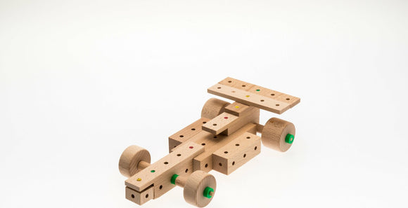 A Cars Explorer DIY kit featuring 50 wooden pieces designed to assemble into a car model. The pieces include colorful wheels and various connectors, promoting creativity and engineering skills.