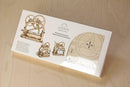 UGears 3D Mechanical Box DIY kit displayed in its packaging. The kit features intricately designed wooden gears and components, showcasing a mechanical puzzle suitable for assembly and display. The package includes images and instructions for building the model, emphasizing creativity and hands-on learning.