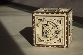 UGears 3D Safe DIY kit featuring an intricately designed wooden box with mechanical parts visible. The structure shows gears and a combination lock mechanism, ideal for puzzle enthusiasts and crafting lovers.