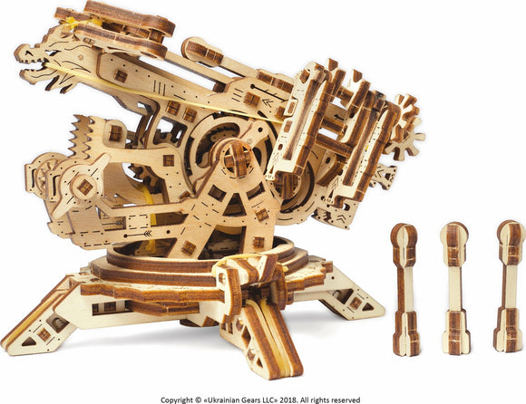 UGears 3D Archballista-Tower DIY kit displayed from the side. The intricate wooden model features gears, moving parts, and a towering design resembling a medieval ballista. Three additional wooden projectiles are placed beside the model, showcasing the craftsmanship and mechanical features.