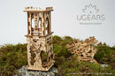 The UGears 3D Archballista-Tower, a detailed DIY mechanical kit featuring intricately designed wooden pieces. The tower has a mix of architectural elements with a beautifully decorated façade, displayed among moss and rocks, capturing a unique blend of creativity and engineering.