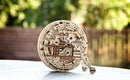 A beautifully crafted UGears 3D Monowheel DIY kit features intricate wooden gears and mechanisms. It showcases a unique design with engraved instructions such as 'FULL AHEAD' and 'STOP'. Perfect for mechanical puzzle enthusiasts and creative individuals looking for an engaging build.