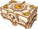 A detailed image of the UGears 3D Amber Box DIY kit, showcasing its intricate wooden design with ornate carvings and decorative amber-like beads on the top. The box features a charming, mechanical construction that invites creativity and hands-on assembly.