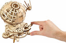 UGears 3D Globe DIY kit showcasing intricate wooden components and mechanical gears. A hand is interacting with the globe to demonstrate its functionality and craftsmanship.