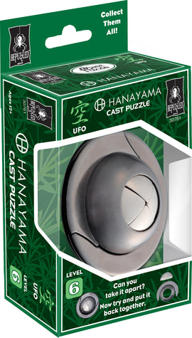 The Cast UFO mechanical puzzle by Hanayama features a sleek, silver design with a circular UFO shape. The packaging highlights its complexity, rated level 6, and invites users to take it apart and reassemble it. The box is green with bamboo patterns and includes text encouraging users to collect them all.