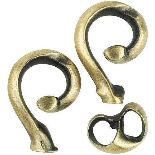 The Cast Radix puzzle by Hanayama features three intricately designed interlocking metal pieces, each with a unique, smooth curve and a subtle bronze finish. The pieces are shaped in a way that challenges the user to detach and reassemble them, showcasing a blend of artistry and mechanical ingenuity suitable for puzzle enthusiasts.