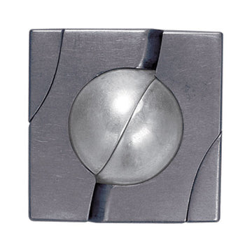 A close-up view of the Cast Marble mechanical puzzle by Hanayama. The puzzle features a metallic square frame with a spherical marble enclosed in the center, showcasing an intricate design with smooth curves and grooves that hint at complex mechanics.