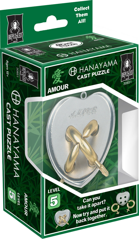 The Cast Amour mechanical puzzle by Hanayama features a heart-shaped design with intricate loops made of metallic materials. The packaging displays the product name and level 5 difficulty, inviting users to take it apart and reassemble it. The vibrant green box includes a spider logo and encourages collectors with phrases like 'Collect Them All!'