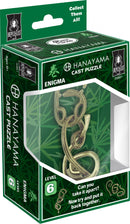 Hanayama Cast Enigma Mechanical Puzzle in a green and black packaging. The puzzle consists of interlocking metal pieces that form a complex design. It features a challenge rating of level 6, indicating advanced difficulty. The packaging displays instructions: 'Can you take it apart? Now try and put it back together', along with the Bepuzzled logo and collection information.